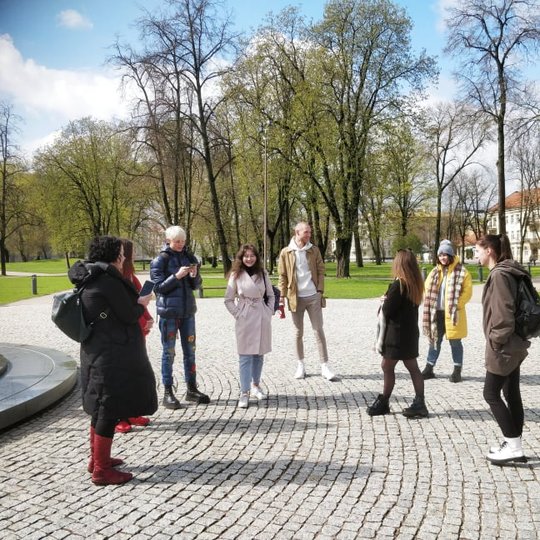 Pažintinė ekskursija po Kreivosios pilies teritoriją (Kalnų parką) su Vilniaus technologijų ir dizaino kolegijos studentais. Grupė stovi prie Karaliaus Mindaugo paminklo.