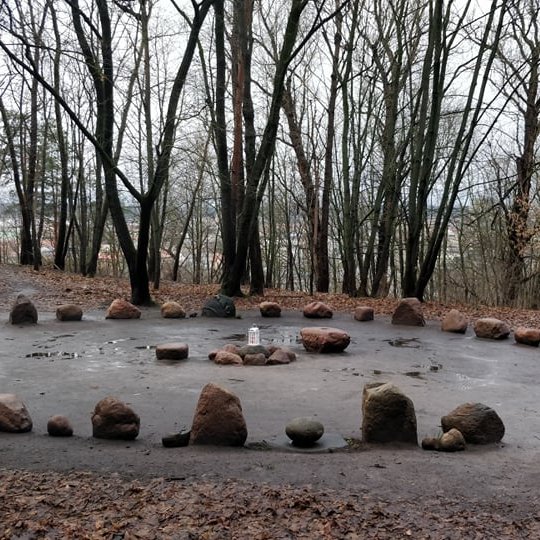Nuotraukoje matomas didelis ratas sudarytas iš vidutinio dydžio akmenų, o rato viduryje akmenų krūva su žvake ant viršaus. Vienoje vietoje paliktas tarpas, neužstatyta akmenimis, matyt, jog tai yra įėjimas į ratą. Aplinkui daug medžių be lapų. Visi lapai