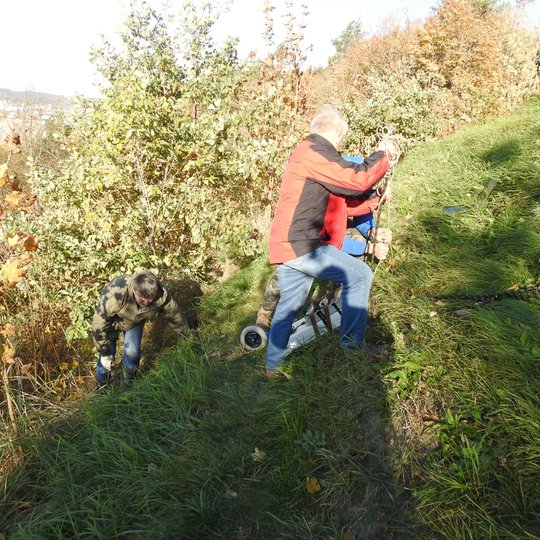 Lietuvos geologijos tarnyba tiria Trijų Kryžių kalną. Keli žmonės kalno šlaite daro tyrimus.