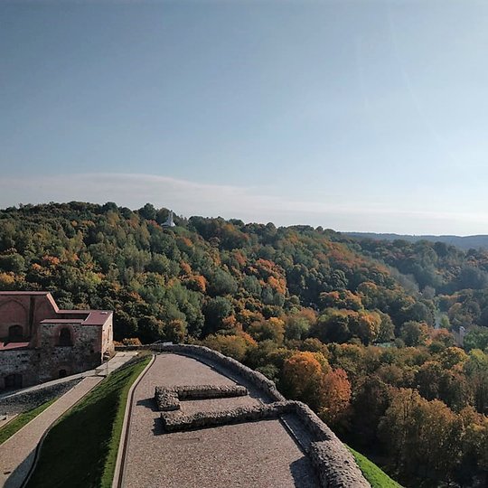 Nuostabi ir šilta rudens diena ir nuotraukoje daug vaiskaus dangaus. Nei vieno debesėlio. Vaizdas nuo Gedimino pilies į Kalnų parką. Daug medžių, kurie pradėjo spalvintis rudens spalvomis. 