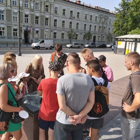 Ekskursijų dalyviai apsupę bronzinį Vilniaus pilių teritorijos maketą, kuris yra Katedros aikštėje.