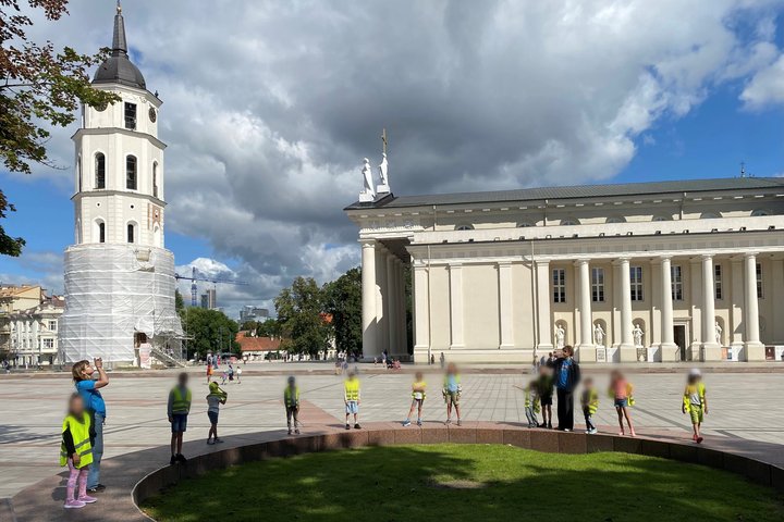 Vaikai su „Bricks4kidz“ stovyklos grupe tyrinėja Vilniaus Katedros aikštę prie varpinės bokšto
