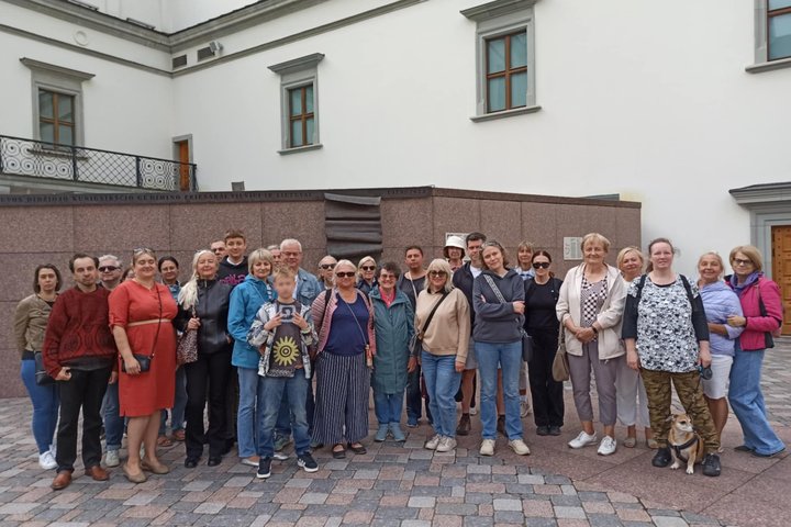 Nuotraukoje didelė žmonių grupė dalyvauja ekskursijoje.