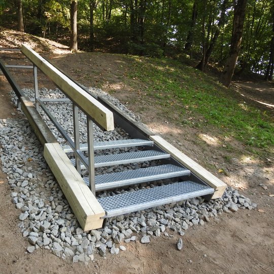 Nuotraukoje geležiniai laiptai su turėklu. Tai laiptų pavyzdys, kaip atrodys Gedimino kapo piliakalnio laiptai.