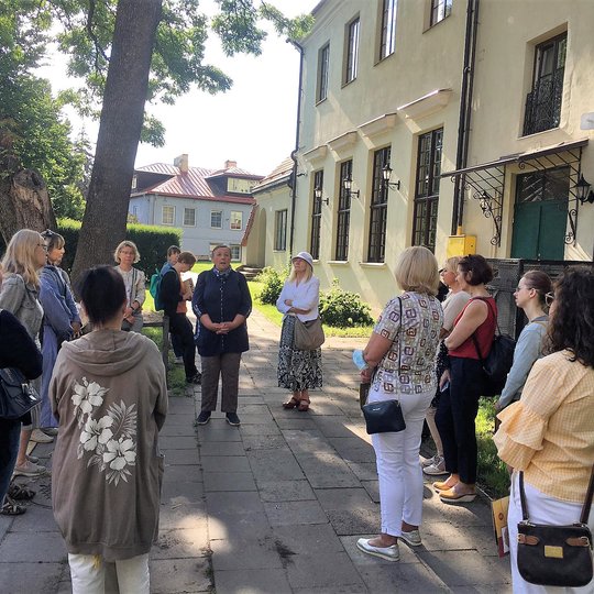 VU botanikos sodo mokslo darbuotojos dr. Silvos Žilinskaitės vedama ekskursija „Botanikos sodas Vilniaus pilyse“. Ekskursijos dalyviai ratu supa lektorę.