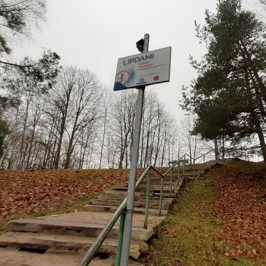 Iškelta ant ilgo koto lentelė - LIPDAMI BŪKITE ATSARGŪS. Tai perspėjimas žmonėms, nes Trijų Kryžių kalno laiptai laukia tvarkymo darbų.