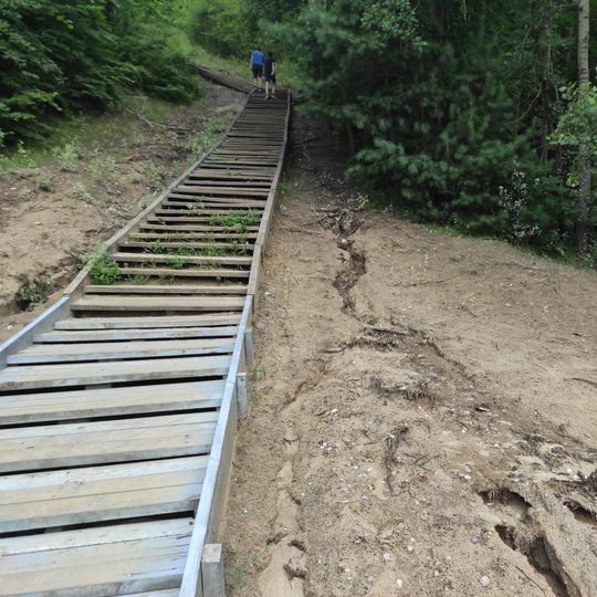Bekešo laiptai, jie kalno viršuje padaro lengvą posūkį į kaire ir dingsta žalumoje. Abipus laiptų taip pat stačios, apaugusios vešlia žaluma, kalvos. Laiptai mediniai. Kelios, pirmutinės, arčiausiame plane pakopos atnaujintos, platesnės. Toliau tęsiasi ne