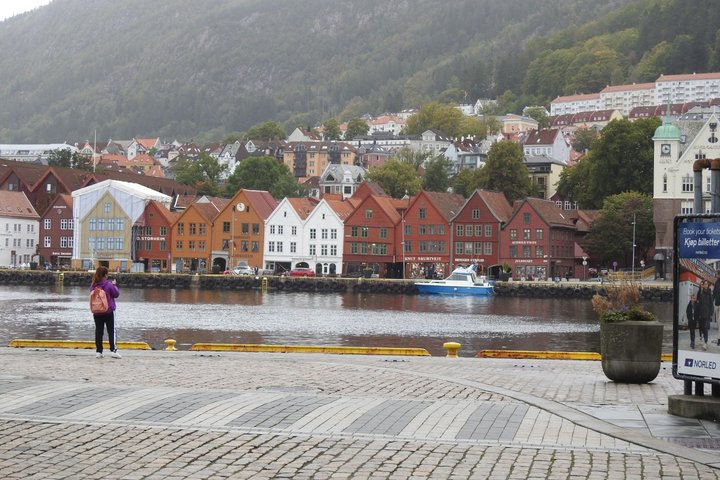 Norvegijos miestas išsidėstęs išsidėstęs prie Šiaurės jūros Byfjordo įlankos ir kalnų. Priekyje nuotraukos yra įvairiomis trinkelėmis grįsta pėsčiųjų krantinė. Dešinėje krantinės stovi masyvus vazonas, prisodintas įvairių gėlių, šalia reklaminis stendas.