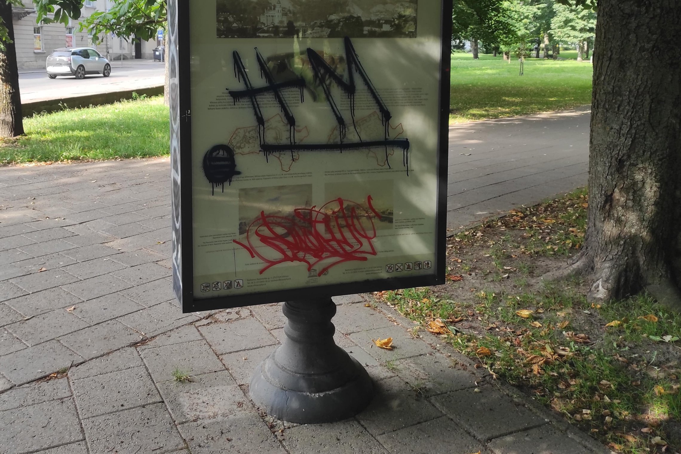  Apipaišytas Vilniaus pilių informacinis stendas, einant Bernardinų sodo link. Nuotraukoje yra stendas, kuriame aprašyta informacija apie Vilniaus pilių valstybinį kultūrinį rezervatą. Stendą yra nuotraukos viduryje, užima didžiąją dalį. Stendo vidurys ta