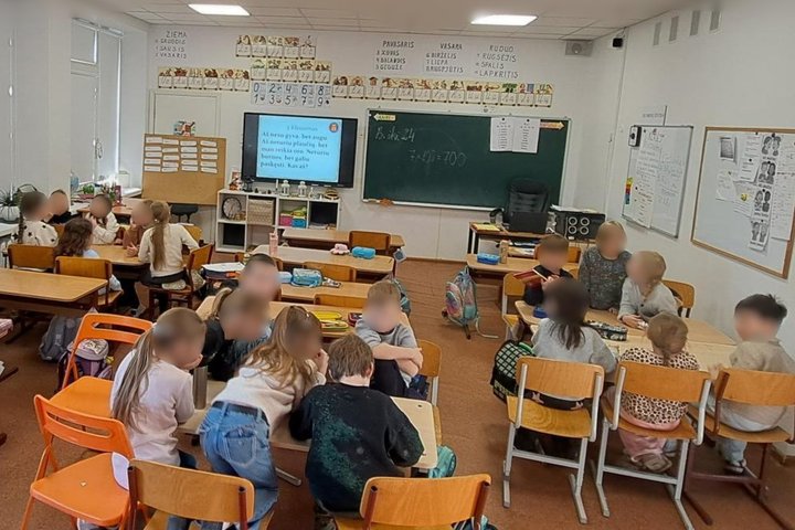 Nuotraukoje vaikai klasėje. Pasidalinę į tris grupes - komandas. Kiekvienos komandos vaikai pasilenkę rašo. Galimai atsakymus į protmūšio klausimus.
