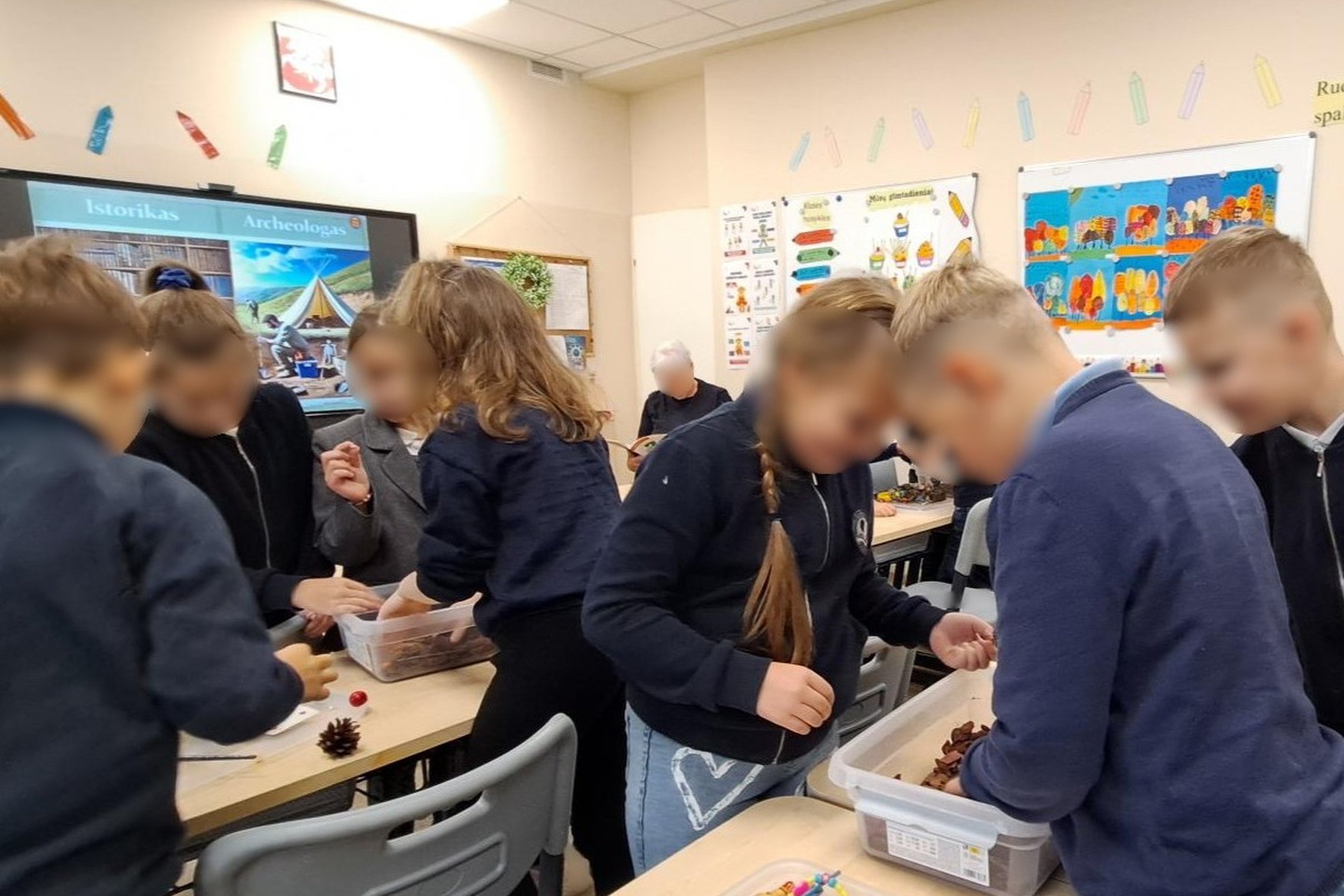 Nuotraukoje mokiniai dalyvauja edukacijoje „Kasinėjant istoriją – skaitant žemės knygas“.