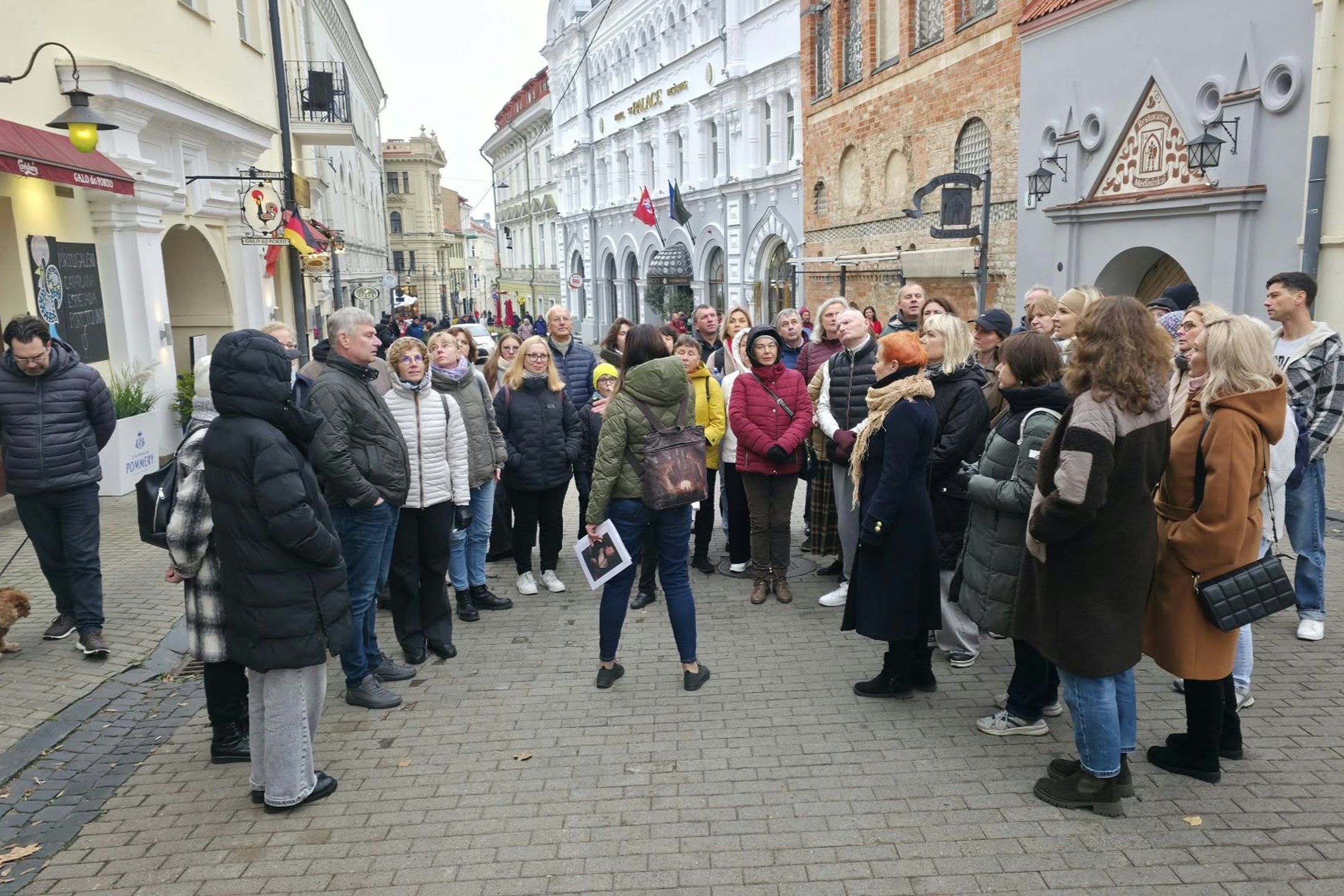Vilniaus senamiestyje susirinkę ekskursijos „Baroko dinastija: trijų Vazų istorija“ dalyviai klausosi pasakojimo.