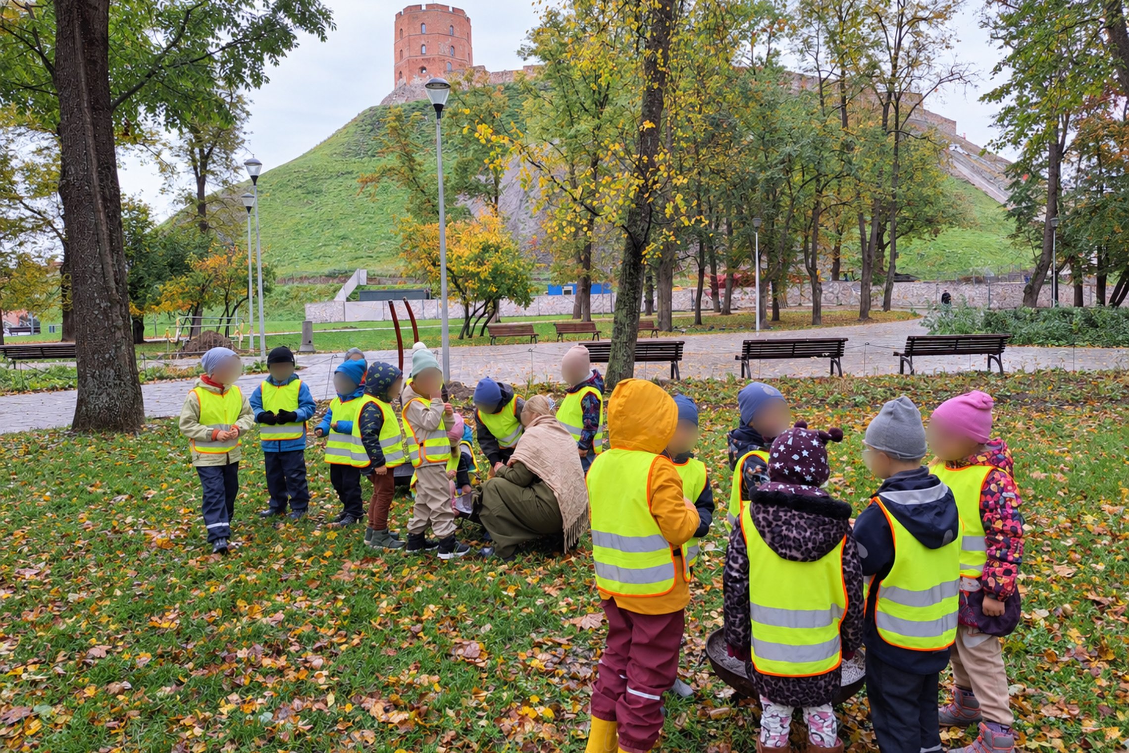 Vaikai su šviesą atspindinčiomis liemenėmis susibūrę Gedimino kalno papėdėje ugnies skeltuvu ir brauktuku bando įžiebti kibirkštį.