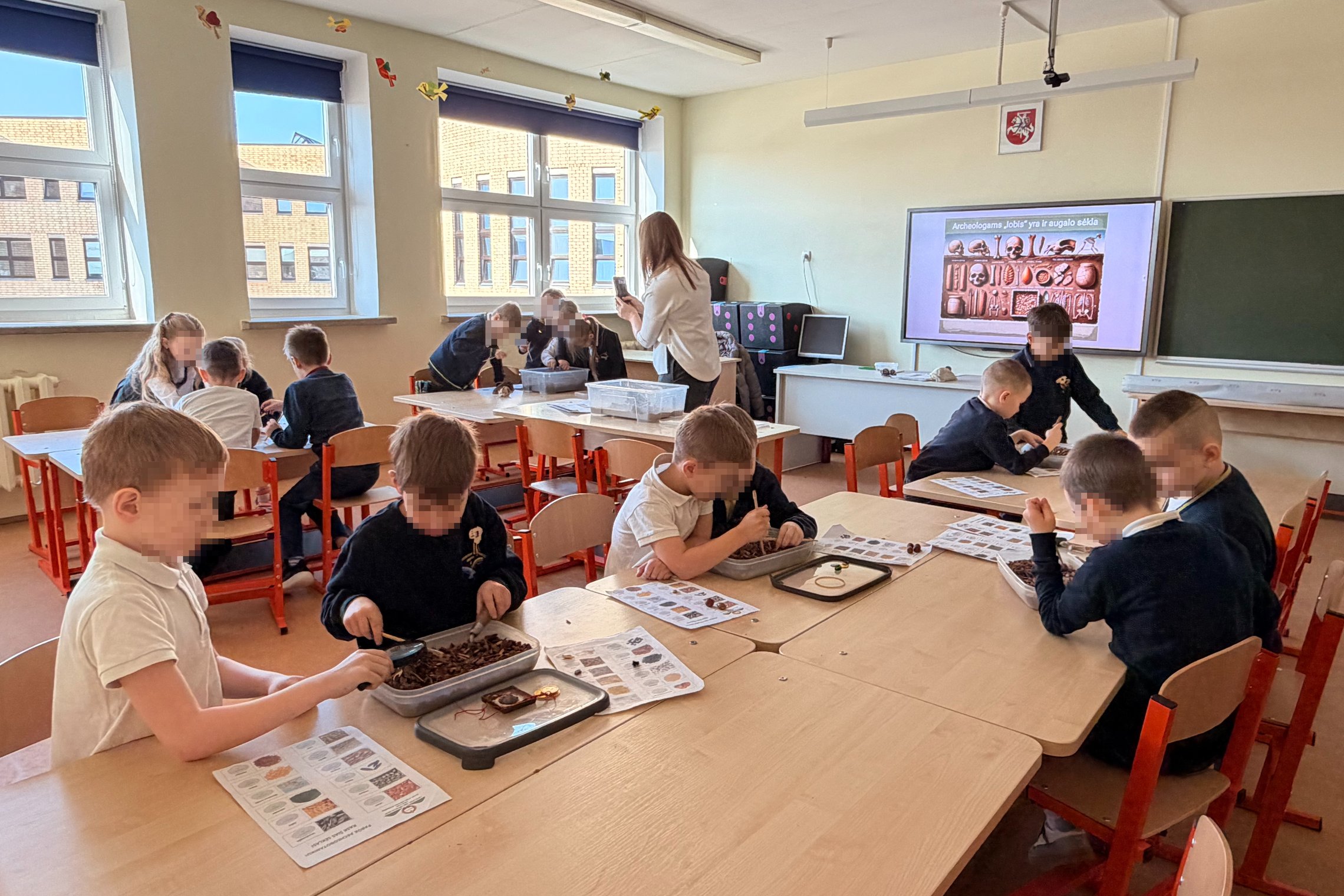 Šalčininkų Lietuvos tūkstantmečio gimnazijos 1a, 1b, 1c ir 4b klasių mokiniai archeologijos edukacijos metu tyrinėja dėžutes su „lobiais“, susipažįsta su archeologo darbu ir dalijasi savo atradimais.