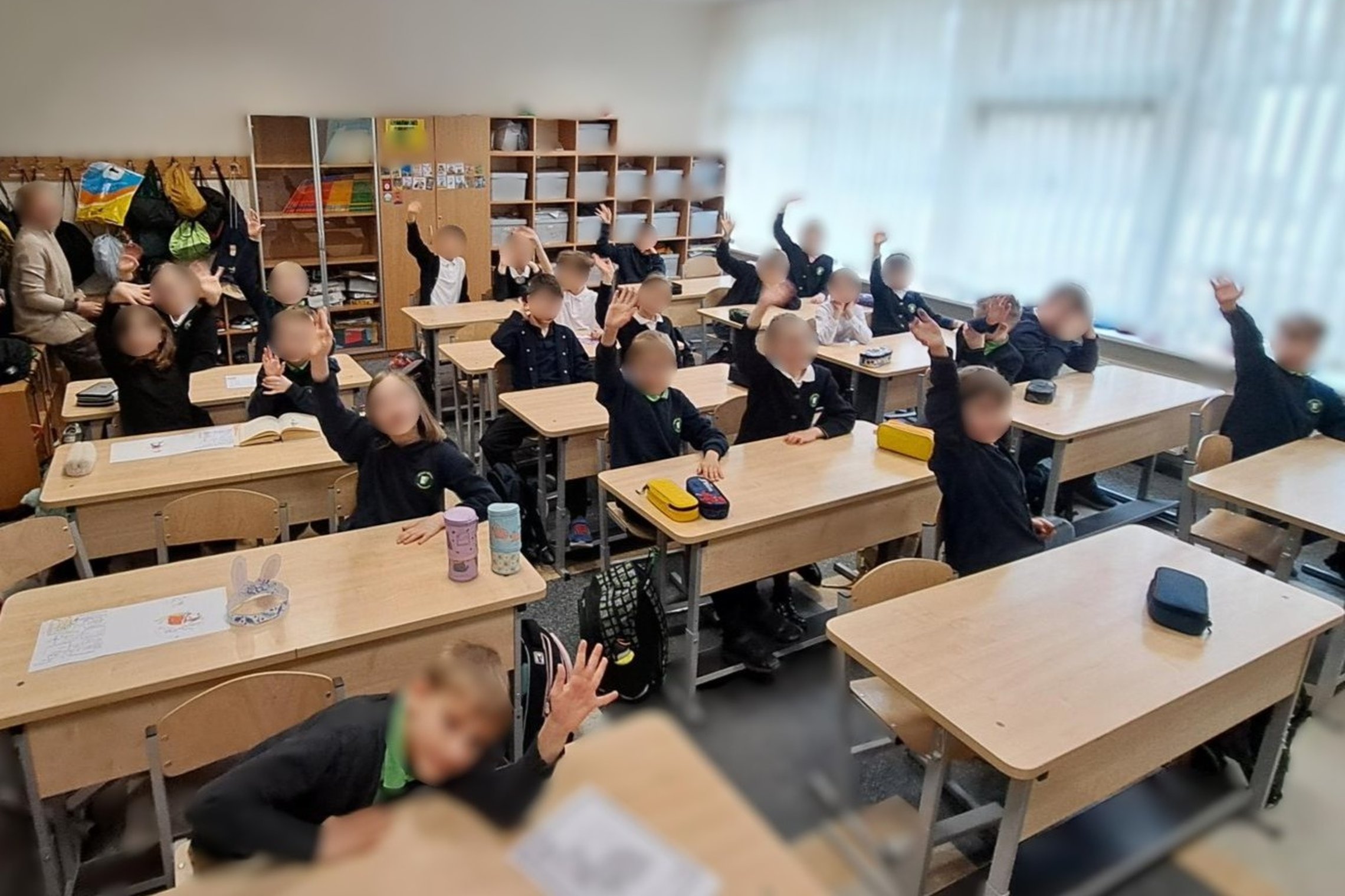 Nuotraukoje mokyklos klasė. Suoluose sėdi mokiniai. Jie dalyvauja edukacijoje „Nuo vienos laisvės iki kitos“.