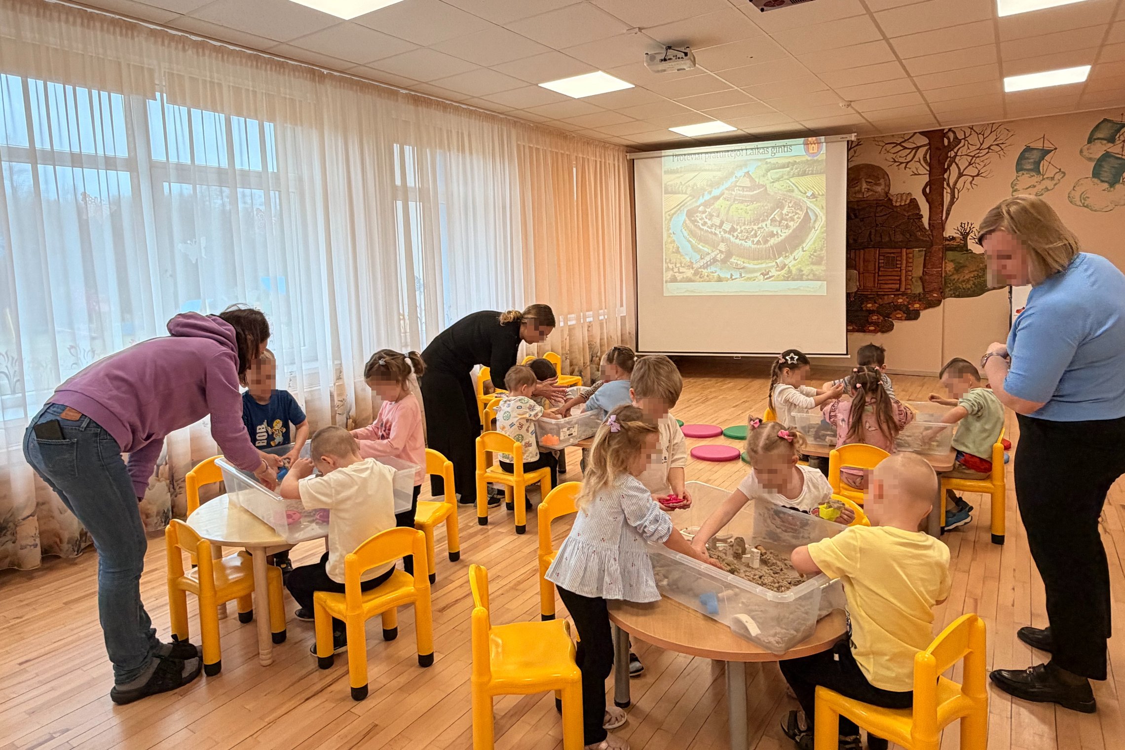 Jašiūnų darželio „Žilvitis“ vaikai grupėmis kuria piliakalnių maketus ir stato medines pilis edukacinės veiklos metu.