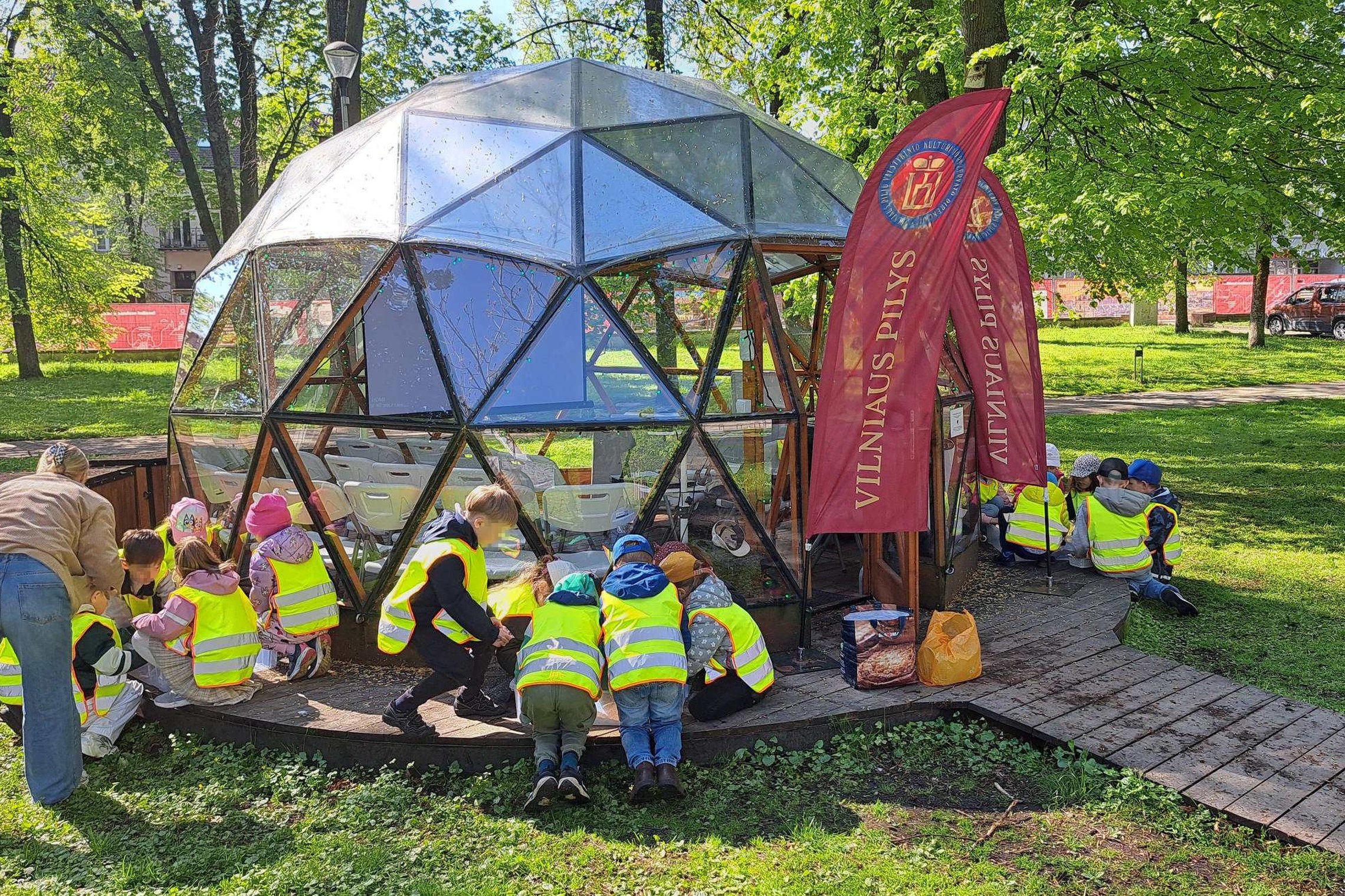 Vilniaus lopšelio-darželio „Lakštingala“ vaikai edukacijos „Piliakalniai ir Vilniaus pilys – ant kalnų gimusi galia“ metu prie Vilniaus pilių edukacinio kupolo žalioje parko aplinkoje.
