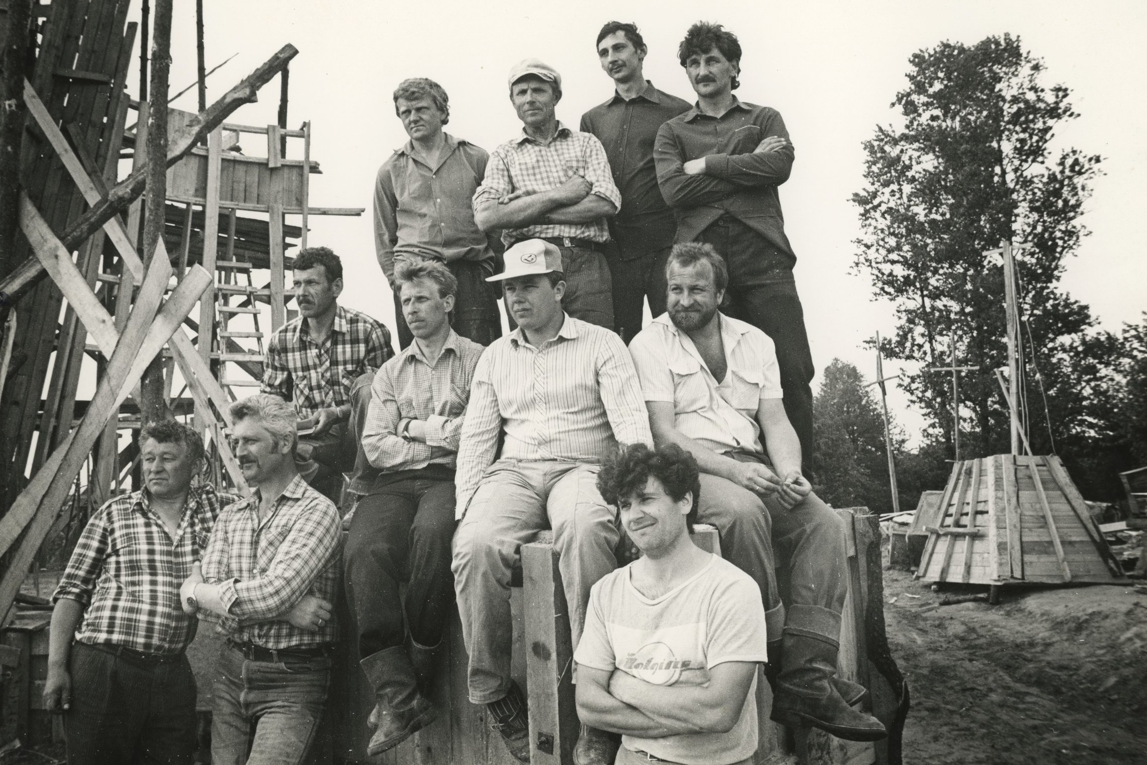 Trijų Kryžių paminklo statytojai 1989 m. gegužę pozuoja statybvietėje prie dar klojiniais apdėto būsimo paminklo.