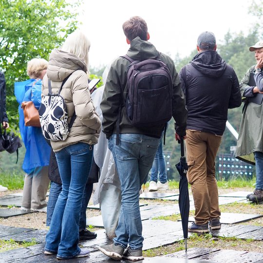 Nuotraukoje gidas veda ekskursiją apie legendas ekskursijos dalyviams.