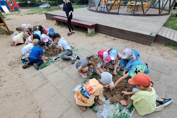 Nuotraukoje vaikai dalyvauja edukacijoje „Kasinėjant istoriją – skaitant žemės knygas“.
