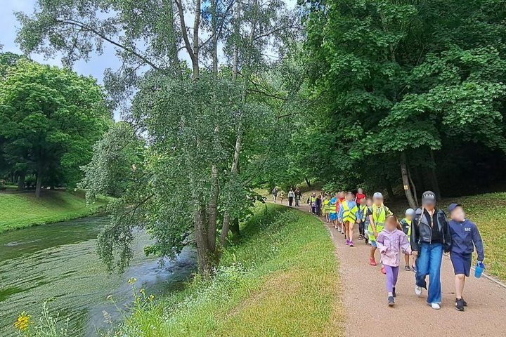 Nuotraukoje didelė vaikų grupė - tai vasaros stovyklautojai keliauja Vilniaus pilių takais. Jie dalyvauja edukacijoje.