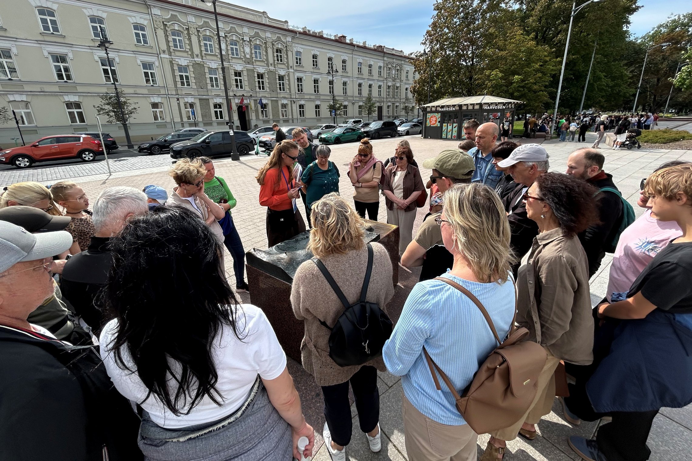 Grupė ekskursantų sustoję aplink Vilniaus pilių maketą Katedros aikštėje.