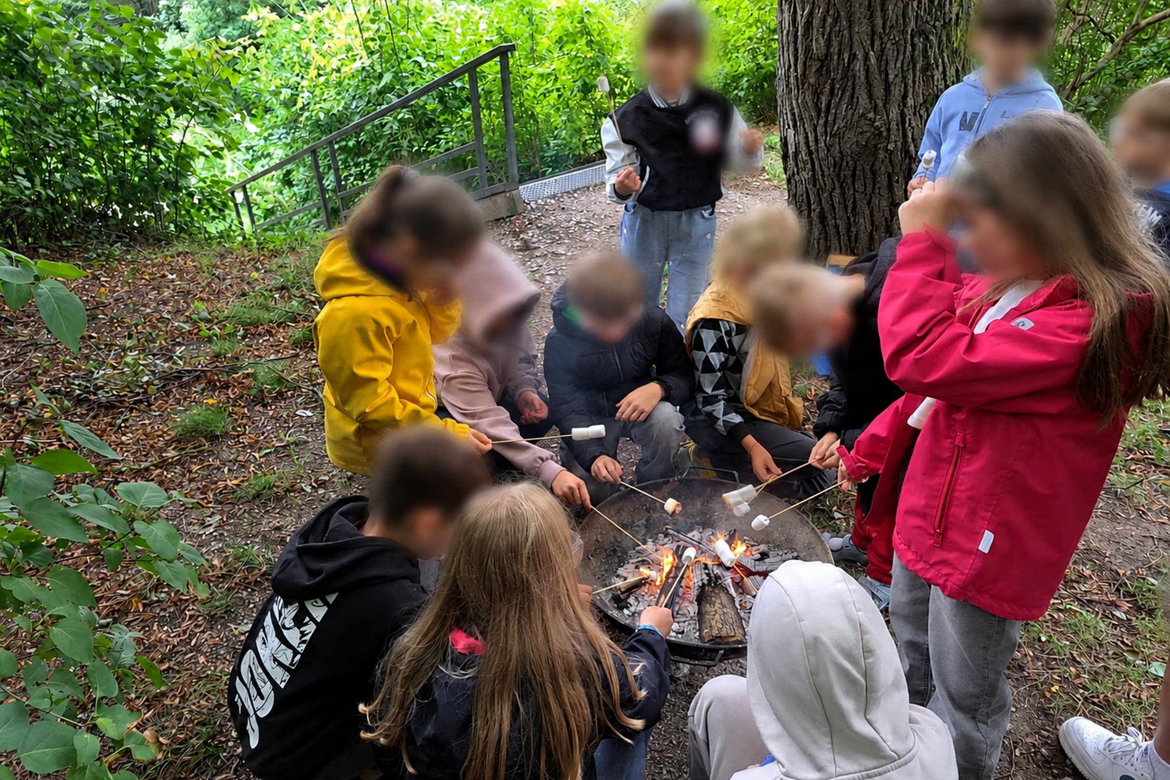 Vaikai Vilniaus pilių teritorijoje, ant Altanos kalvos, dalyvauja ugnies edukacijoje – susibūrę aplink laužą mokosi apie ugnies reikšmę žmogaus istorijoje ir kepa zefyrus.